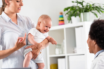 The consultant pediatrician with the baby patient and mother