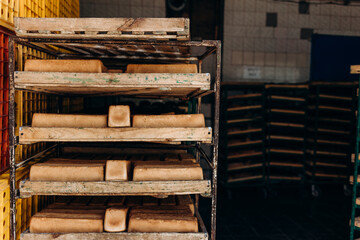 Bread loaves fresh only baked on a wooden cart rack. Wooden trolley with bread for baking just pulled out of the oven, a lot of white loaves of bread