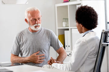 Female doctor examining an elderly patient at her office