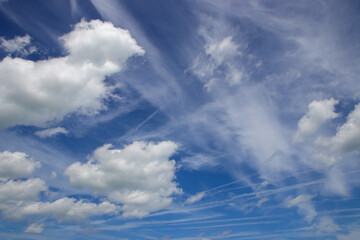 wolken und kondesstreifen am blauen himmel