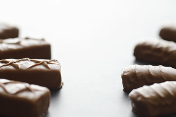 Chocolate bars on a black background in backlight. Chocolate with filling. Sweet sweets for snack and tea.