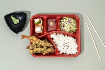 MIXED TEMPURA regular BENTO with sauce and chopsticks isolated on red background top view of...
