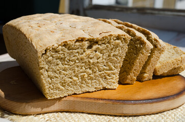 Handmade bread on a wooden board, on a wheat