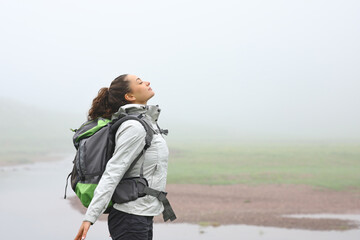 Hiker breathing fresh air in the mountain a foggy day