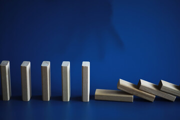 Closeup thick domino wood block in a row stop the falling, be stable in crisis, business solution concept
