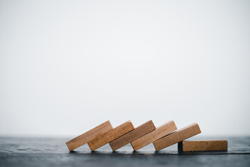 Wooden blocks and domino effect risk management concept business success, problem solving, strategy development
