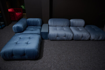Stylish modern large blue satin sofa bed displayed for sale in a furniture store