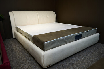 Modern stylish velour double beds with orthopedic hard mattresses, displayed in the showroom of a...