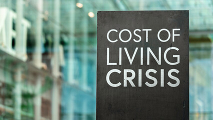 Cost of Living Crisis in front of a modern office building	
