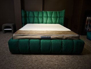 Sylish soft sleeping bed made of emerald green velour upholstery with orthopedic mattress displayed...