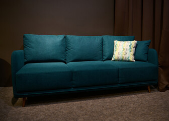 Stylish green sofa bed with green and beige cushion displayed for sale in the upholstered furniture design showroom