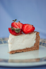 Delicious strawberry cheesecake on a purple background. A slice of fresh perfect cheesecake cake