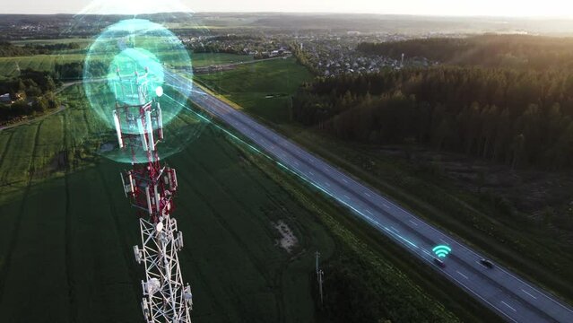 Aerial footage: radio signal from the 5g cell tower is transmitted to cars driving on the highway. Visualization of a wireless Internet signal transmission system to cars while driving.