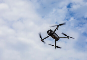 Fototapeta na wymiar Flying drone on cloudy sky background