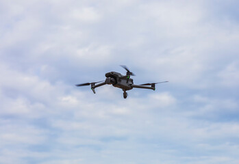 Fototapeta na wymiar Flying drone on cloudy sky background