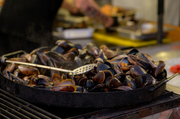 Cooked fried mussels with lemon. Street seefood