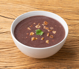 Black bean soup in a bowl over wooden table