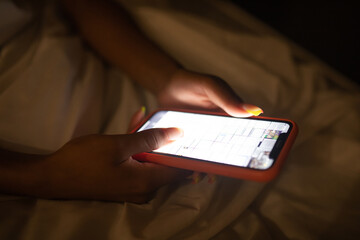 Girl typing a message in a dark room close-up.