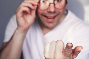 The concept of poor vision. Hold a contact lens and glasses in hand. A poster for advertising...