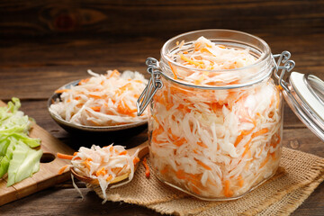 Fresh pickled cabbage - sauerkraut with carrot on a wooden table.