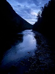 River between mountains in the blue hour of the day.