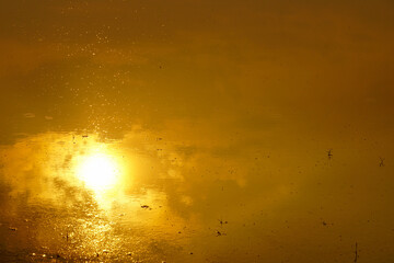 sunset reflected in the water in the evening.	