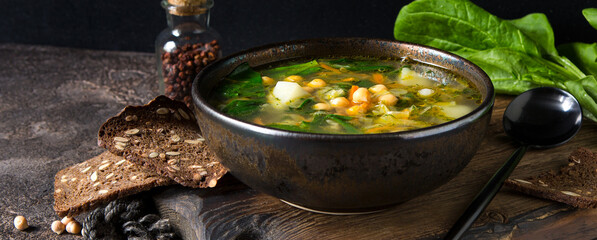bowl of soup with spinach and chickpeas on a dark table