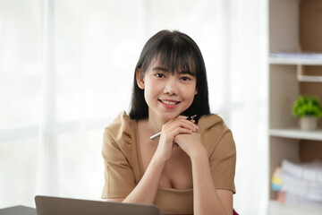 Happy smiling business woman using laptop for working and study at home or office space.