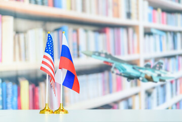 Flag of USA and Russian federation on a table with a blurred fighter jet. A symbol of cooperation...