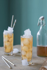 Refreshing iced tea. Summer natural drink in a glass bottle and tall glasses for cocktails.