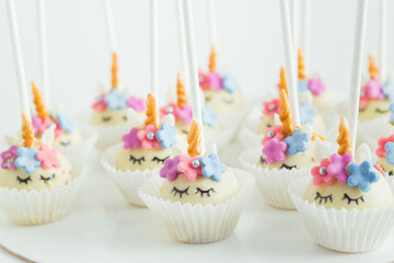 Unicorn cakepops covered with white chocolate on the white background