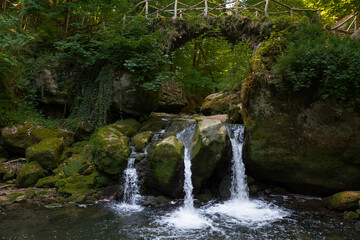 Fototapeta na wymiar waterfall the schiessentumpel and bridge in luxembourg