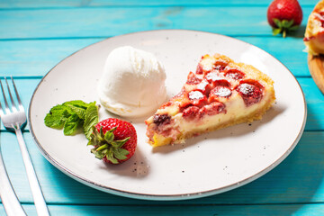 Homemade strawberry custard tart decorated with strawberry and ice cream on wooden background.