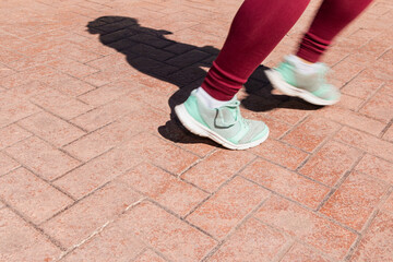 Fototapeta na wymiar Runner's feet in motion on the pavement