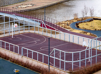 Air view empty soccer football field with sport gear wet rainy spring or autumn weather near the river residential district area.