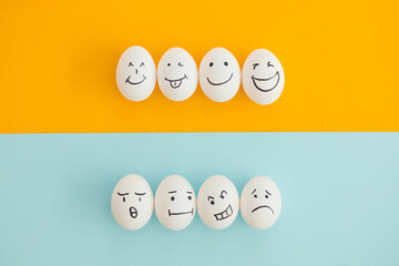 Smiling and sad eggs on a yellow-blue background