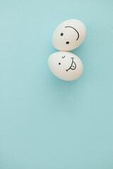 Smiling and sad eggs on a blue background