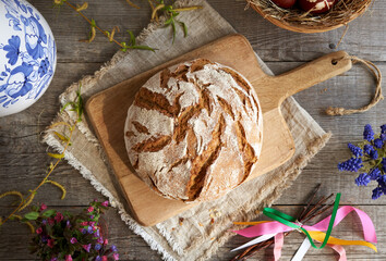 A loaf of sourdough bread with spring flowers and Easter decoration