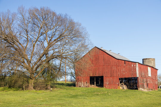 Old red wooden barn in a field