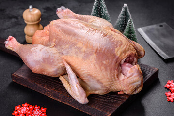 Raw turkey or chicken with salt, spices and herbs on a wooden cutting board. Preparing a christmas table