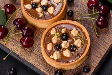 Delicious fresh nougat and nut tart with fresh berries on a wooden cutting board