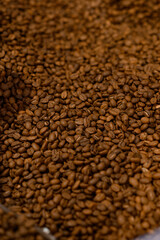 close up view of coffee beans roasting in machine