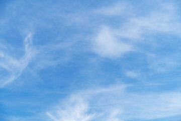 Blue sky with beautiful light white cirrus clouds on a warm sunny day.