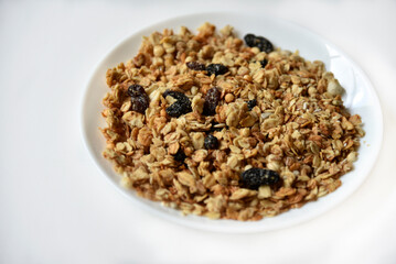 Muesli with nuts and raisins on a white plate