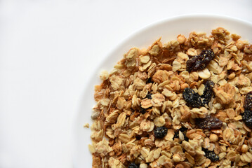 Muesli with nuts and raisins on a white plate
