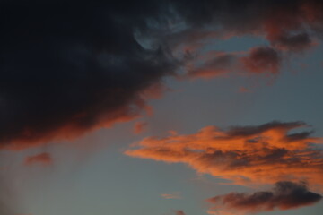 Blue sky at sunset with red glowing and black clouds background image