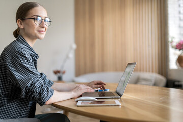A woman with glasses is a freelance economist who works, uses a laptop, makes a report to a...