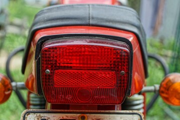 rear large marker stop signal of red color on an old metal motorcycle made in the soviet union on...