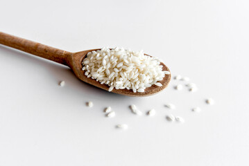 Fototapeta na wymiar Arborio rice on wooden spoon, risotto rice on white background.