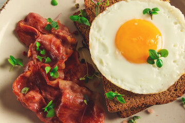 Breakfast, fried egg with bacon, micro-green, on a light background, no people, selective focus,